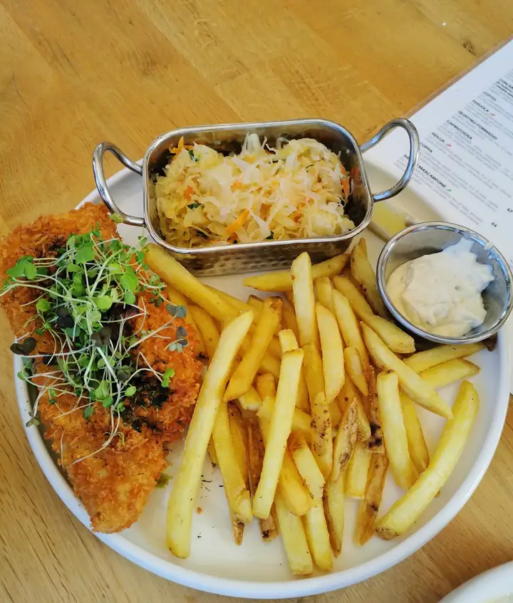 Kotlet z frytkami i surówką na stole